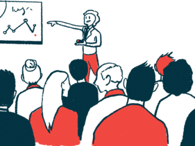 A person points to a chart on a wall while making a presentation in front of a crowd.