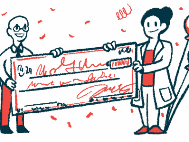 Two people hold a giant check.