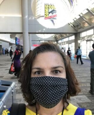 A selfie photo of a woman wearing a face mask at a comic convention.